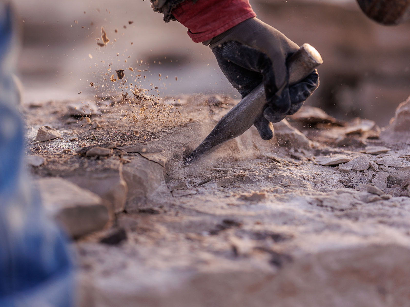 Stone mason uses a chisel to shape stone in the Rademann Stone quarry