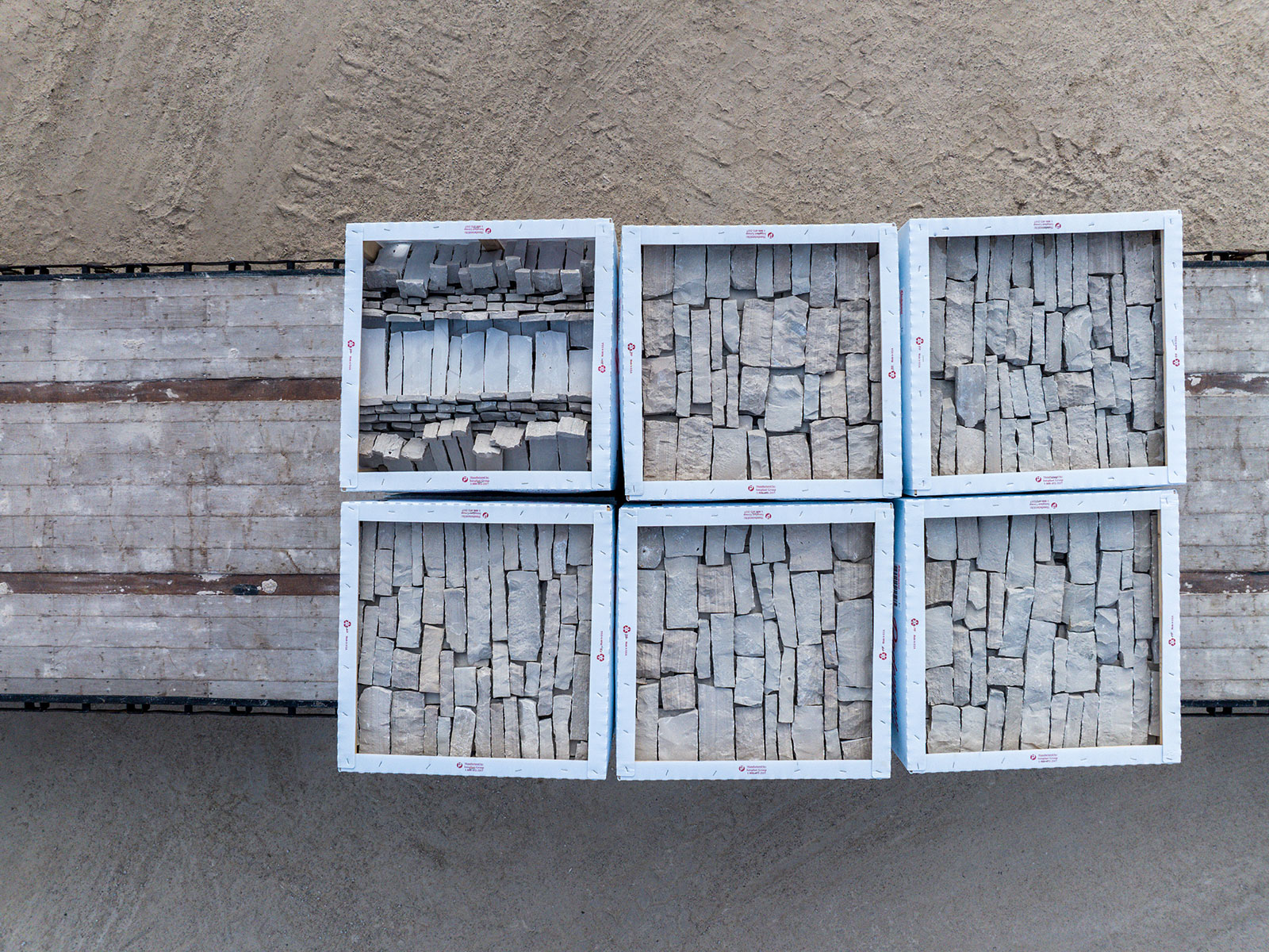 Directly overhead 6 boxes of Rademann Stone on a flatbed trailer