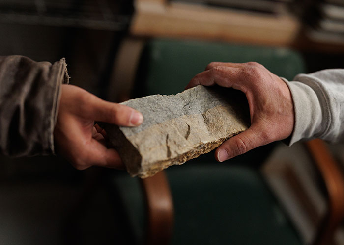 Close up of a Rademann stone being handed from one person to another.
